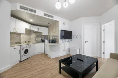 a kitchen with white cabinets and a table in a room at Stunning Lake View - Height Floor - Furnished 1BR in Dubai
