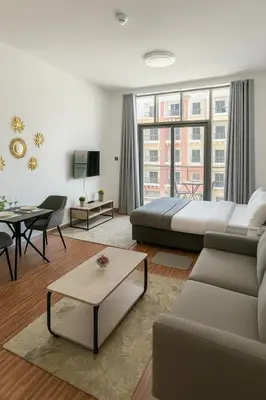 a living room with a bed and a couch at Cozy Apartment in Jumeirah Village Circle, Dubai. in Dubai