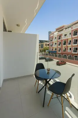 a balcony with a table and two chairs and a view at Cozy Apartment in Jumeirah Village Circle, Dubai. in Dubai