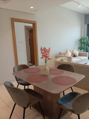 a living room with a table and chairs and a couch at Appartement Dubai in Dubai