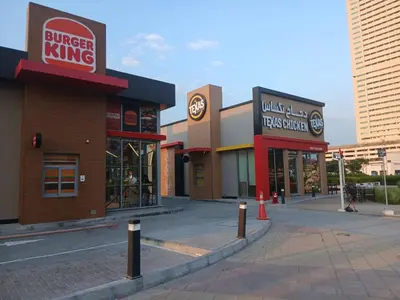 an empty street with a burger king building at Appartement Dubai in Dubai