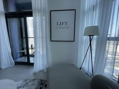 a living room with a couch and a picture on the wall at Iconic !Luxurious 1 Bed Apartment! in Dubai