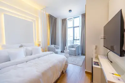 a hotel room with a bed and a flat screen tv at Le Villa-Joie !Bright Studio Apartment! in Dubai