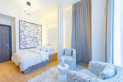 a bedroom with a bed and a chair at Le Villa-Joie !Bright Studio Apartment! in Dubai