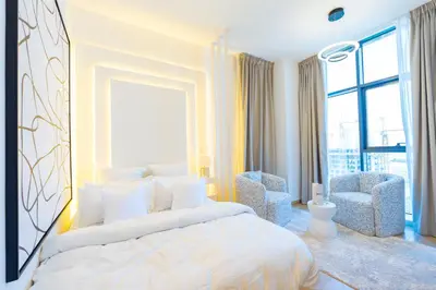 a bedroom with a large bed and two chairs at Le Villa-Joie !Bright Studio Apartment! in Dubai