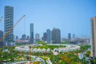 a city with tall buildings and construction cranes at Le Villa-Joie !Bright Studio Apartment! in Dubai