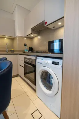 a kitchen with a washing machine in a kitchen at STAY BY LATINEM Luxury 1BR Holiday Home CVR A2910 Near Burj Khalifa in Dubai