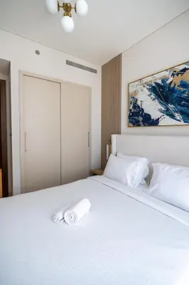a white bed with a towel on top of it at STAY BY LATINEM Luxury 1BR Holiday Home CVR A2910 Near Burj Khalifa in Dubai