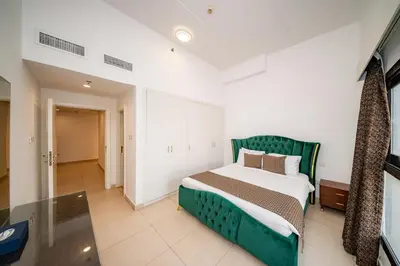 a bedroom with a green bed in a room at City Stay Residences - Serviced Apartments DIP in Dubai