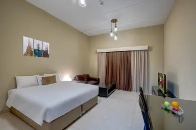a bedroom with a large white bed and a couch at City Stay Residences - Serviced Apartments DIP in Dubai