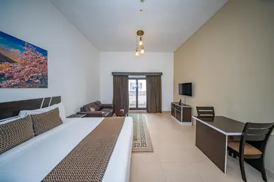 a bedroom with a bed and a desk and a couch at City Stay Residences - Serviced Apartments DIP in Dubai