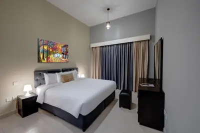 a bedroom with a large white bed and a window at City Stay Residences - Serviced Apartments DIP in Dubai