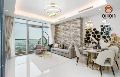 a living room with a couch and a table at Paramount 2 Bed Apt, Roof Top Bar and Pool overlooking Burj, Triple Balcony, Fully Equipped, Free Toiletries, Full Kitchen, 2 and half Bathrooms, Ground Floor Supermarket, Influencers Haven, Sunrise and Sunset Views over the Sea From All Balcony in Dubai