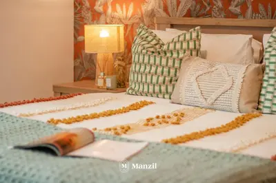 a bed with two pillows and a remote control on it at Manzil - Luxury 3BR Villa w/ maid room, Full Burj & Fountain view in Dubai