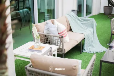 a porch with a couch and a table with a vase at Manzil - Luxury 3BR Villa w/ maid room, Full Burj & Fountain view in Dubai
