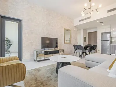a living room with a couch and a tv at Fantastic 1 BR in Park Point - Dubai Hills in Dubai