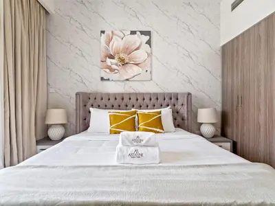 a bedroom with a large bed with yellow pillows at Fantastic 1 BR in Park Point - Dubai Hills in Dubai