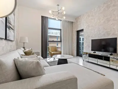 a living room with a couch and a tv at Fantastic 1 BR in Park Point - Dubai Hills in Dubai