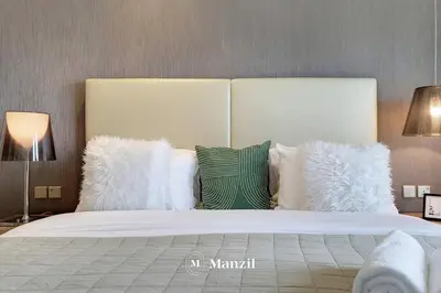 a bedroom with a large bed with white pillows at Manzil - Ultra Luxury 1BR apartment Paramount Tower with Burj Khalifa and Downtown Views in Dubai