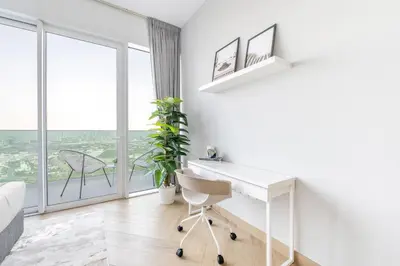 a white desk and chair in a room with a window at Ultra Luxury Wasl 1 Residences Zabeel Park in Dubai