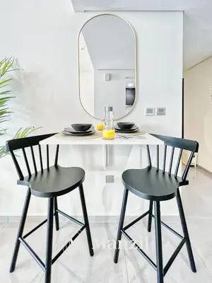 a dining table with two chairs and a mirror at Elegant 3BR in a Prime Location Near Metro, Business Bay in Dubai