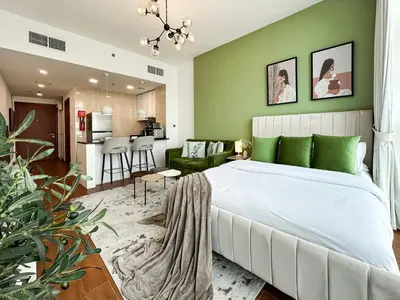 a bedroom with a white bed and a green wall at Trophy - Urban Oasis Suite in Dubai