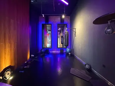 a room with a gym with purple lights and a door at Trophy - Urban Oasis Suite in Dubai