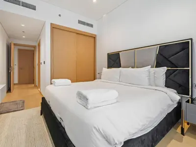 a bedroom with a large white bed with white pillows at Elegant Apartment Amidst Vibrant Area With Balcony in Dubai