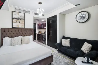 a bedroom with a bed and a couch and a clock at Cozy JLT Studio Lakeview Pool Metro Access in Dubai