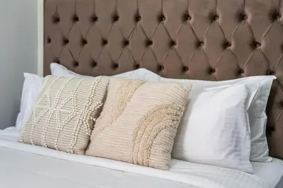 a bed with white pillows and a brown headboard at Cozy JLT Studio Lakeview Pool Metro Access in Dubai