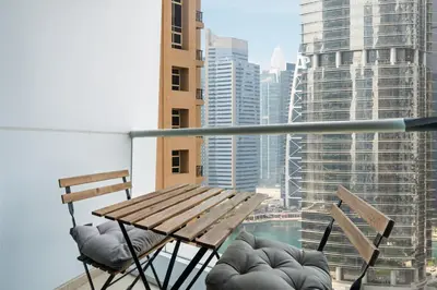 a table and chairs on a balcony with a view of a city at Cozy JLT Studio Lakeview Pool Metro Access in Dubai