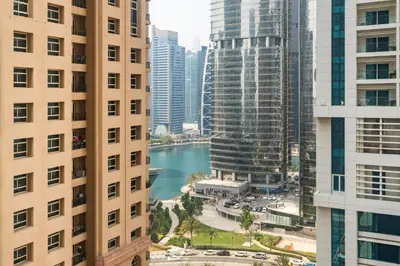 a view of a river between two tall buildings at Cozy JLT Studio Lakeview Pool Metro Access in Dubai