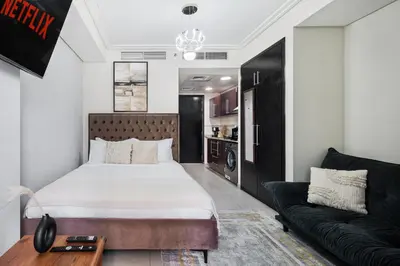 a bedroom with a large bed and a couch at Cozy JLT Studio Lakeview Pool Metro Access in Dubai