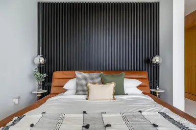 a bedroom with a bed with a black and white headboard at GuestReady - Beachfront heaven with stunning views in Dubai
