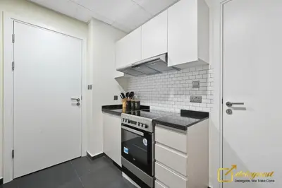 a kitchen with white cabinets and a stove at Dubai Private Pool villa Damac Hills 2 deleguest in Dubai