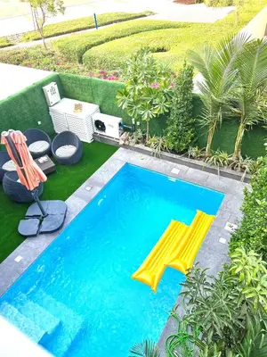 a swimming pool with two chairs and a yellow umbrella at Dubai Private Pool villa Damac Hills 2 deleguest in Dubai