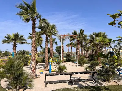 a park with a bench and some palm trees at Dubai Private Pool villa Damac Hills 2 deleguest in Dubai