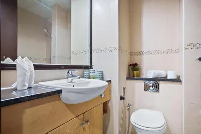 a bathroom with a sink and a toilet and a mirror at Luxury JLT Studio Lakeview Pool & Marina Walk in Dubai