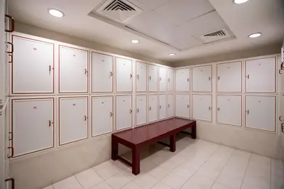 a locker room with white cabinets and a wooden bench at Luxury JLT Studio Lakeview Pool & Marina Walk in Dubai