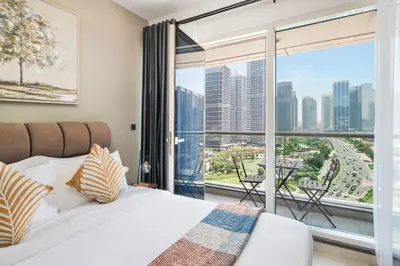 a bedroom with a bed and a large window at Furnished studio in Arch Tower, JLT near metro in Dubai