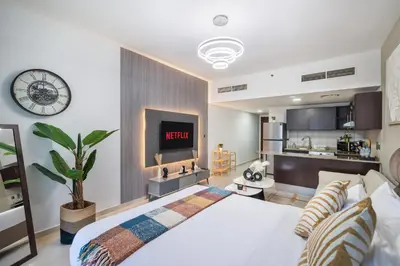 a bedroom with a bed and a clock on the wall at Furnished studio in Arch Tower, JLT near metro in Dubai