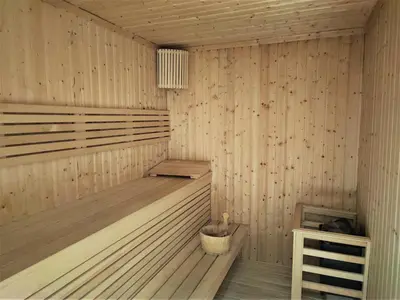 a wooden sauna with a bucket in it at Sleek and Stylish 2-Bedroom Apartment in Dubai