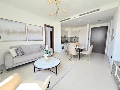 a living room with a couch and a table at Sleek and Stylish 2-Bedroom Apartment in Dubai