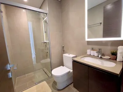 a bathroom with a toilet and a shower and a sink at New 1 bedroom in Sobha Hartland in Dubai
