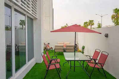 a patio with a table and chairs and an umbrella at Exquisite Villa - Elegant Living in Dubai