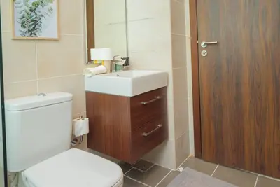 a bathroom with a toilet and a sink and a mirror at Exquisite Villa - Elegant Living in Dubai