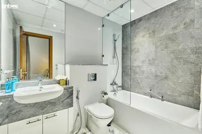 a bathroom with a toilet and a sink and a shower at bnbme - Luxury 2BR Business Bay Apt w Canal Views Pool Gym Free Parking Downtown in Dubai