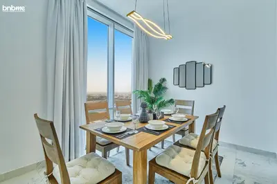 a dining room with a wooden table and chairs at bnbme - Luxury 2BR Business Bay Apt w Canal Views Pool Gym Free Parking Downtown in Dubai