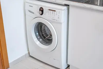 a white washer and dryer in a kitchen at Spacious Serene Studio Retreat in JVC by Suiteable in Dubai