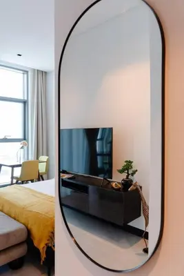 a mirror in a room with a tv and a bedroom at Stylish studio next to canal in Dubai